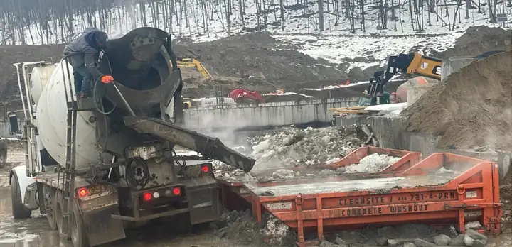 Ready-mix truck washing its chute out into a CleanSite concrete washout container