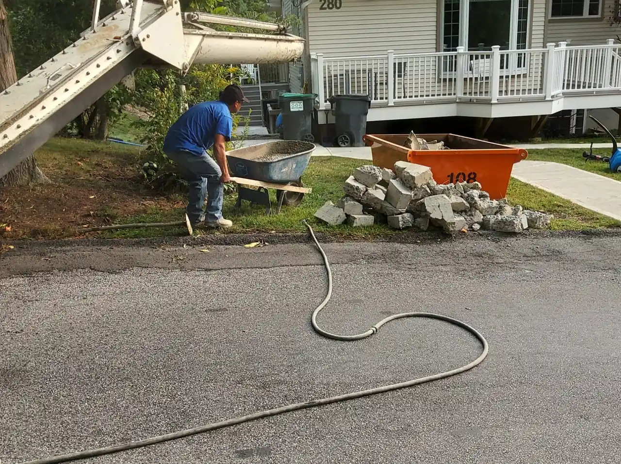 CleanSite washout pan beside a house while a crew works from a concrete chute