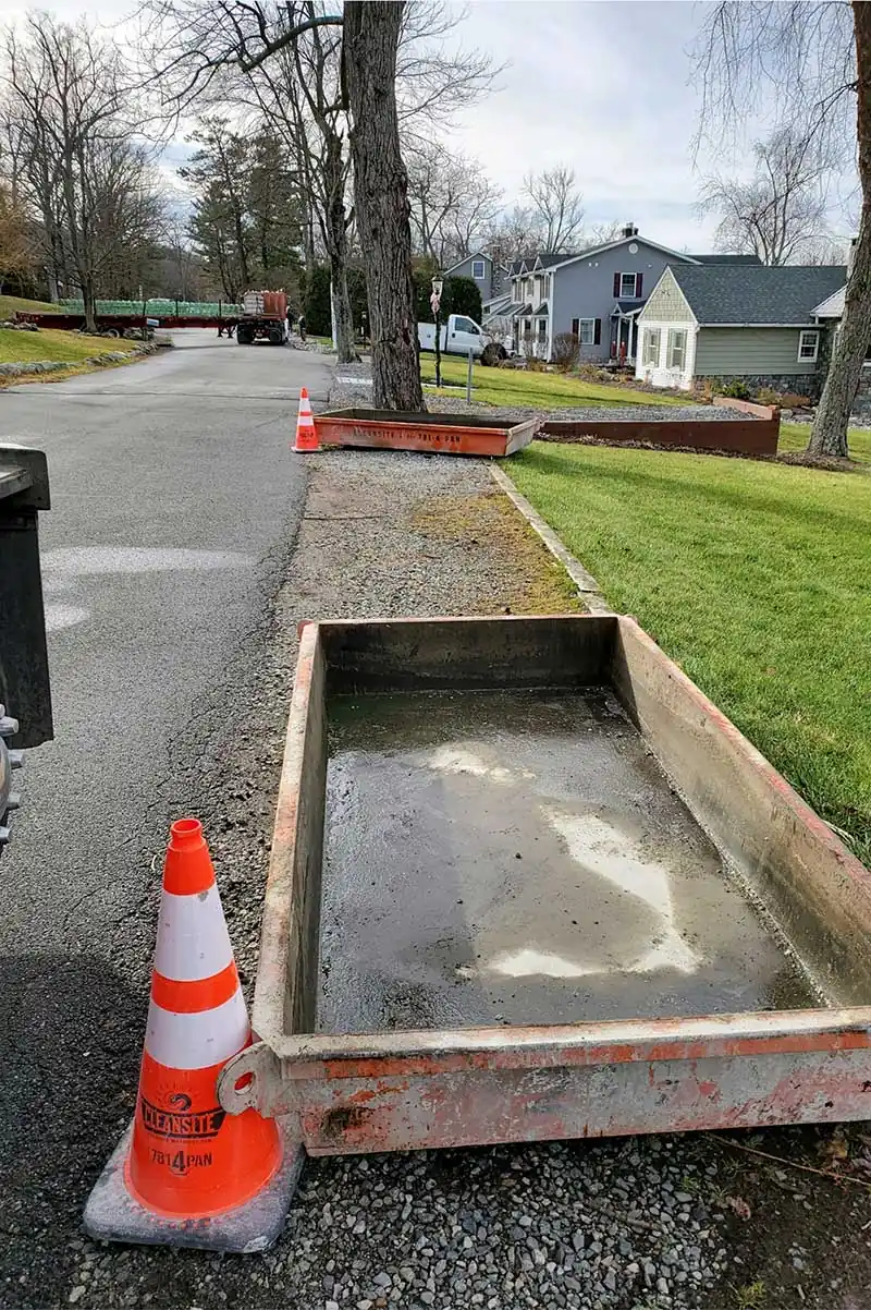 Small CleanSite pan on a sidewalk with a traffic cone