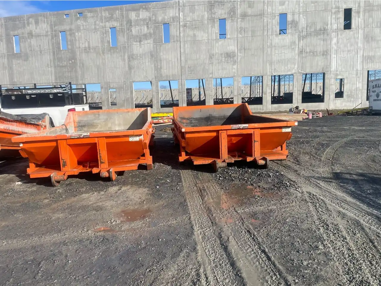Two CleanSite washout containers in front of a concrete tilt-up building