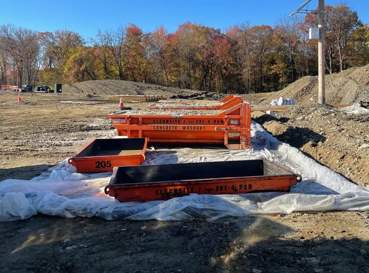 CleanSite washout pans and a container set on a liner at an open site